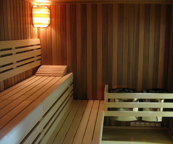 Interiér finské sauny s lavicemi a kamny